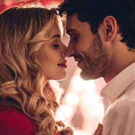 Couple amoureux partageant un moment tendre, front contre front, dans une ambiance chaleureuse et romantique. couple-romantique-saint-valentin