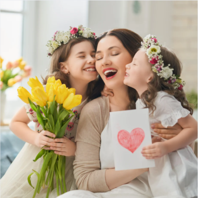 Mère comblée recevant des tulipes jaunes et un dessin en forme de cœur de la part de ses deux filles, pour la fête des mères. fete-des-meres-enfants-tulipes-dessin-coeur