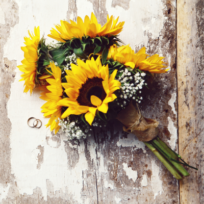 Petit bouquet de tournesols au style rustique, accentué par un fond bois vieilli, parfait pour une décoration vintage ou une ambiance champêtre. bouquet-tournesols-style-rustique