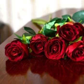 Bouquet de roses rouges ouvertes posées sur cerceuil