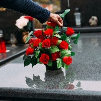 bouquet de roses rouges sur tombe