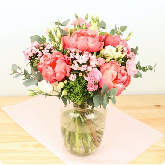 Composé d'élégantes pivoines corail ou rose et de jolies fleurs de saison dans les tons pastel, Douceur de pivoine est un bouquet plein de fraîcheur et de délicatesse.