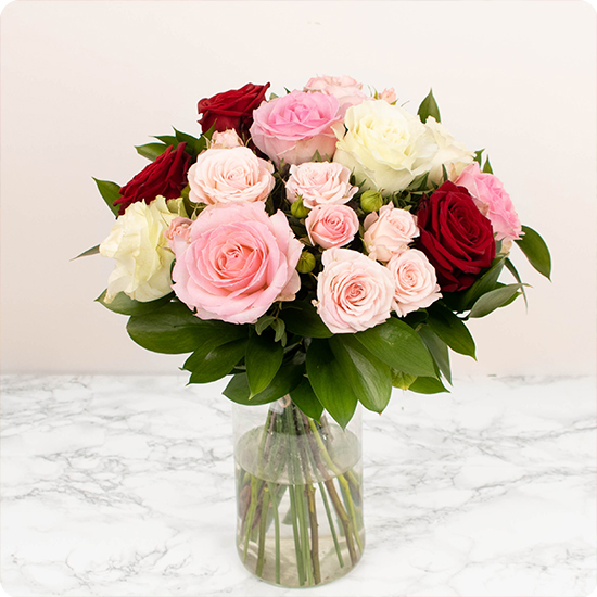 Élégant bouquet pour deuil composé de roses de couleur rose, symbolisant l'affection, blanche, signe de pureté et de respect, et rouge, synonyme d'amour.