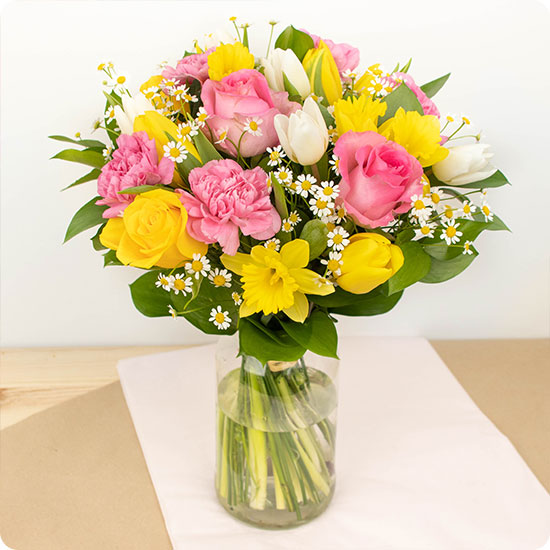 Composé de belles roses et de charmantes fleurs de saison dans les tons roses, jaunes et blancs, Happiness est un bouquet gorgé de joie et de douceur printanière.