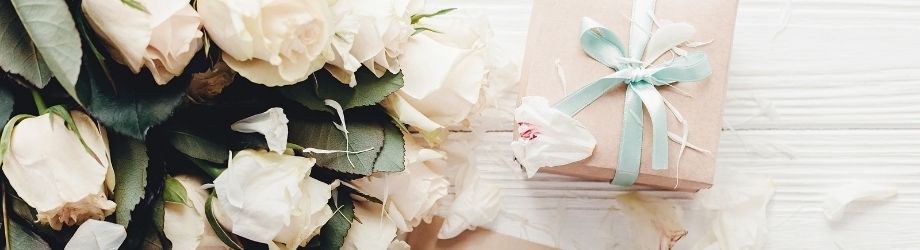 Bouquet de roses blanches avec cadeau à noeud bleu