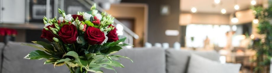Gros bouquet de rose rouge posé devant le canapé