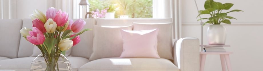 salon avec canapé beige et table rose avec jolie brasée de tulipes colorées roses et blanches