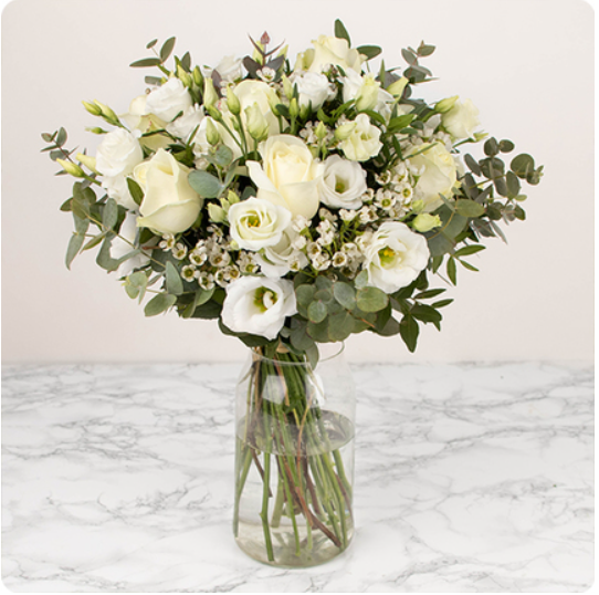 composé de belles roses blanches, de petites fleurs de saison et de feuillages fins et délicats.