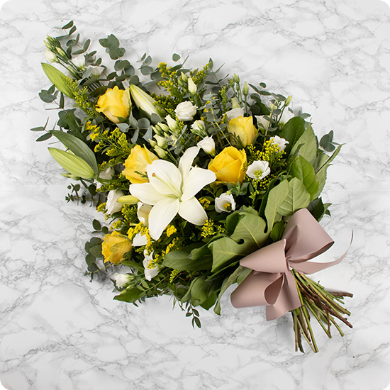 Cette gerbe de fleurs pour deuil est composée de majestueux lys, de roses jaunes et de délicates fleurs de saison agrémentées d'un feuillage finement travaillé.